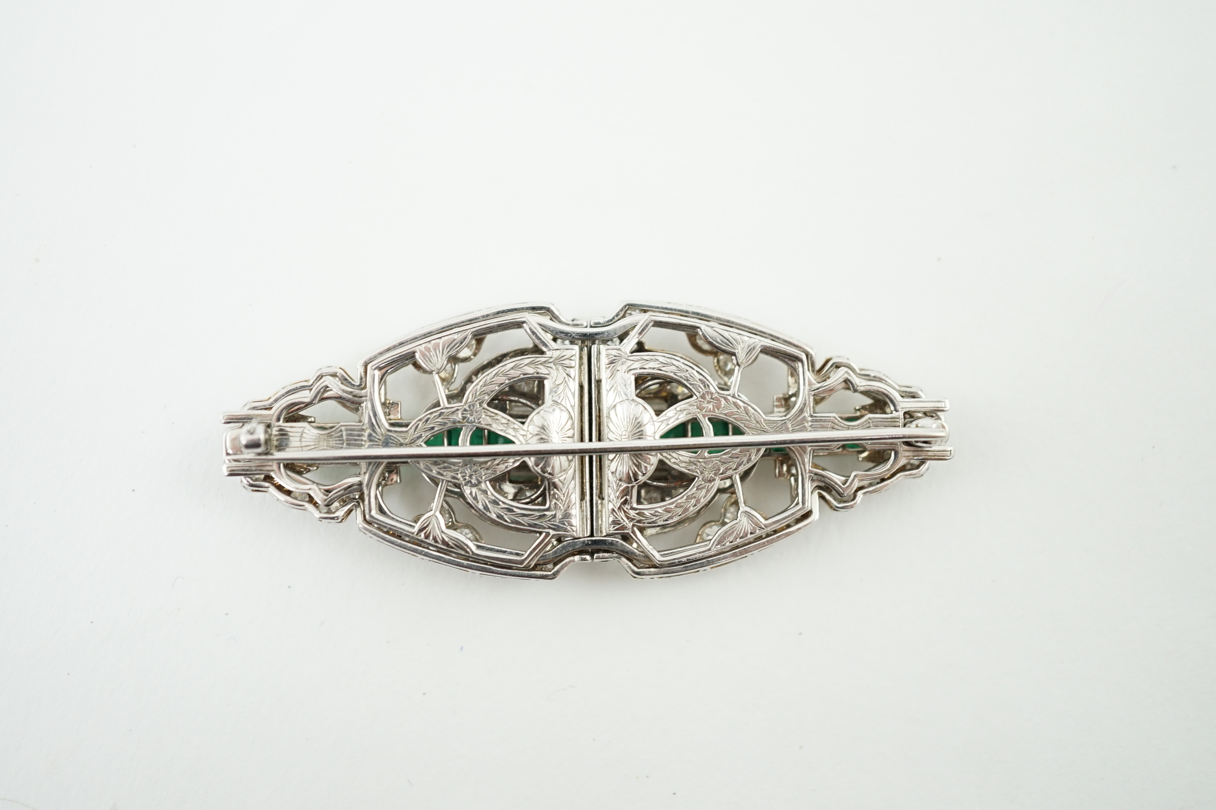 A 1930's/1940's white gold, emerald and diamond double clip brooch